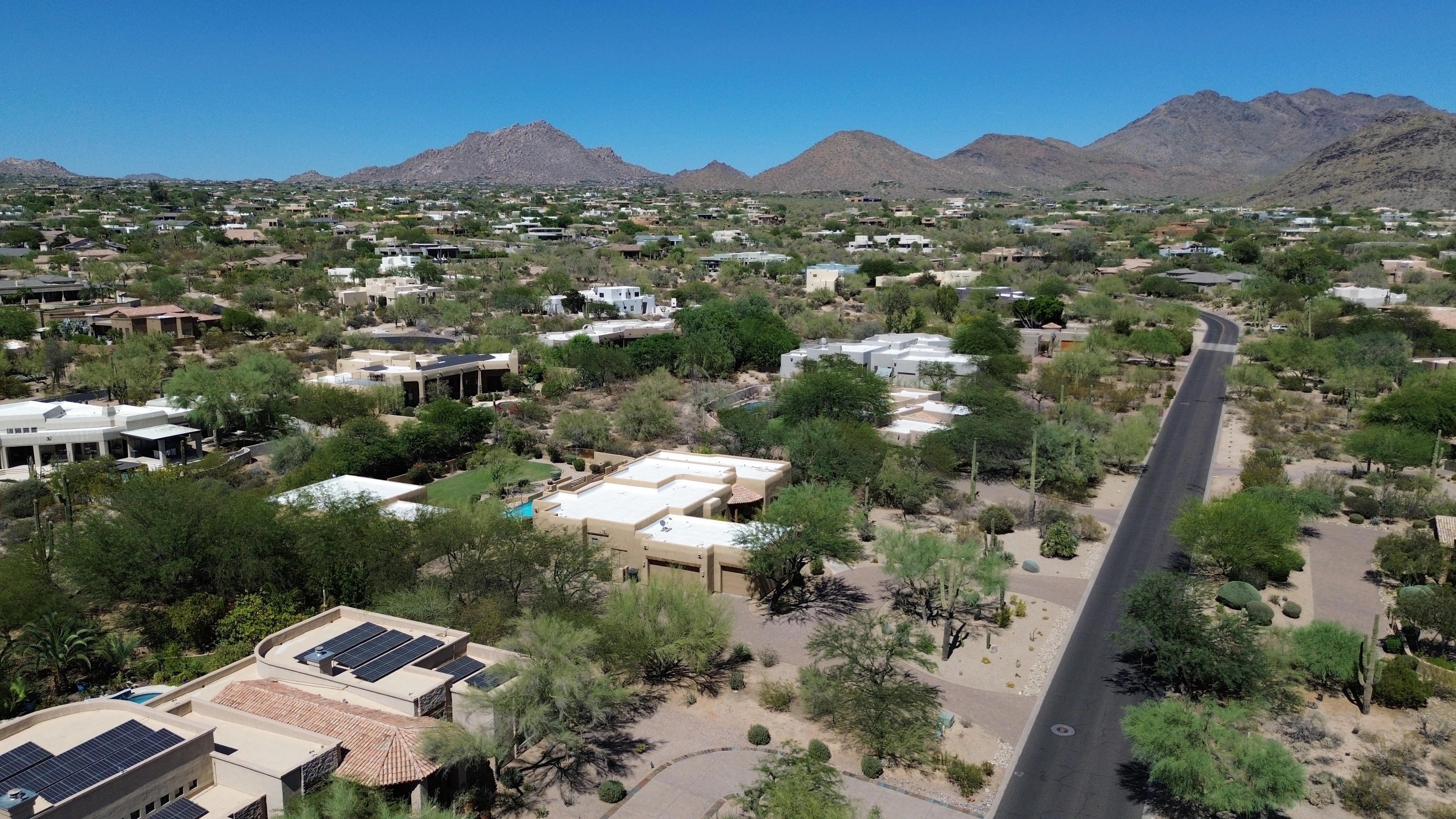 Desert residential lots, a neighborhood road, and mountain views in Arizona